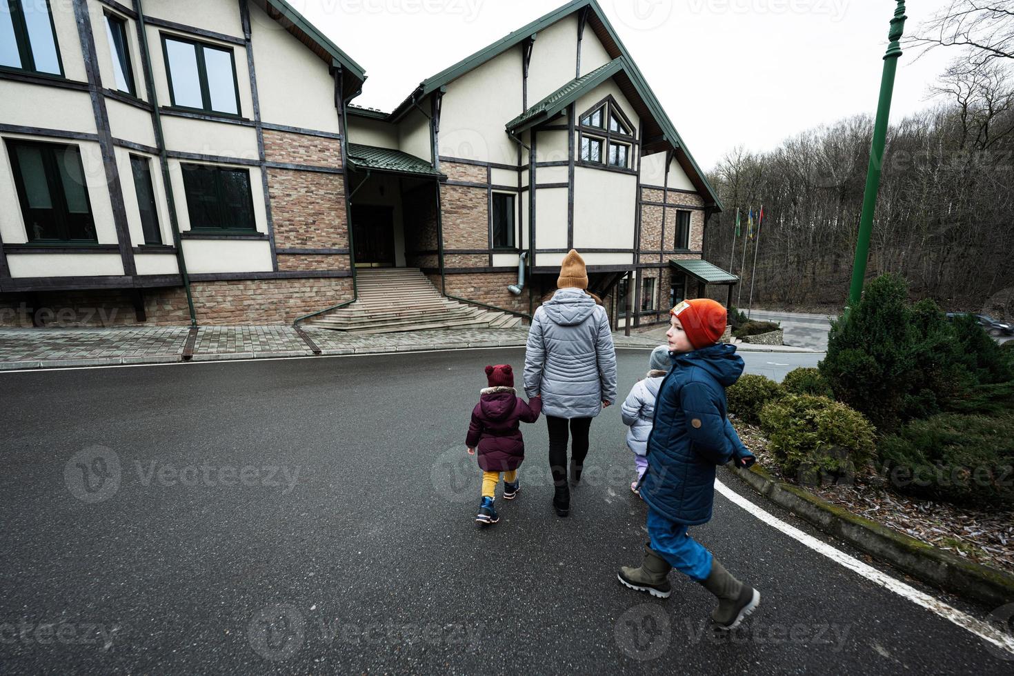 Family walking on path near wooden cottage in the forest. Country house. photo