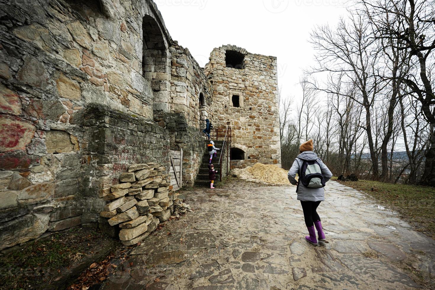 Mother and children visit an ancient medieval castle fortress. photo