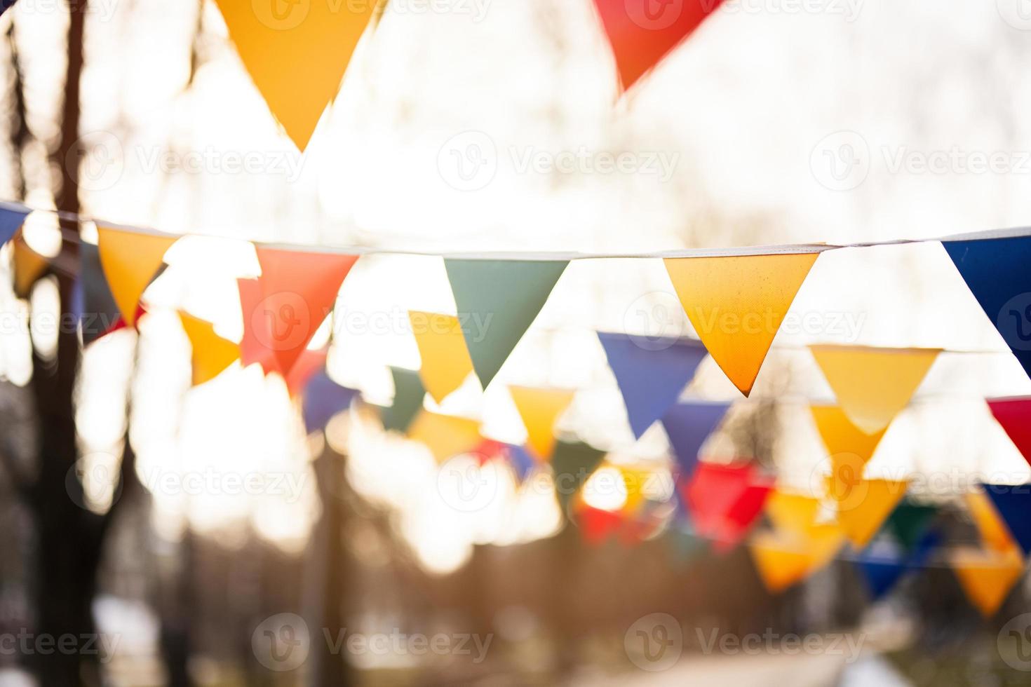 Colorful triangular flags against sunset sky. photo