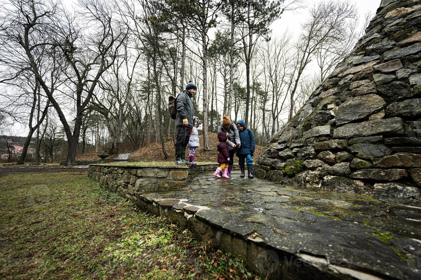 familia turista con Tres niños, estar cerca Roca Monumento en bosque. foto