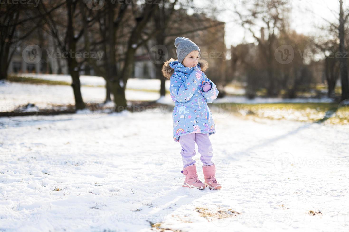 Baby girl posed in winter sunny day. photo