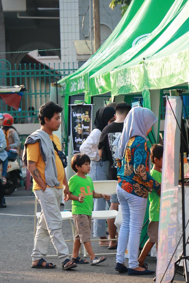 felicitaciones, diciembre 2022. foto retrato de el kudus expo micro, pequeño y medio empresas, con varios tipos de ropa, comida y bebidas situado en el kudus cuadrado concurrido con vendedores visitantes