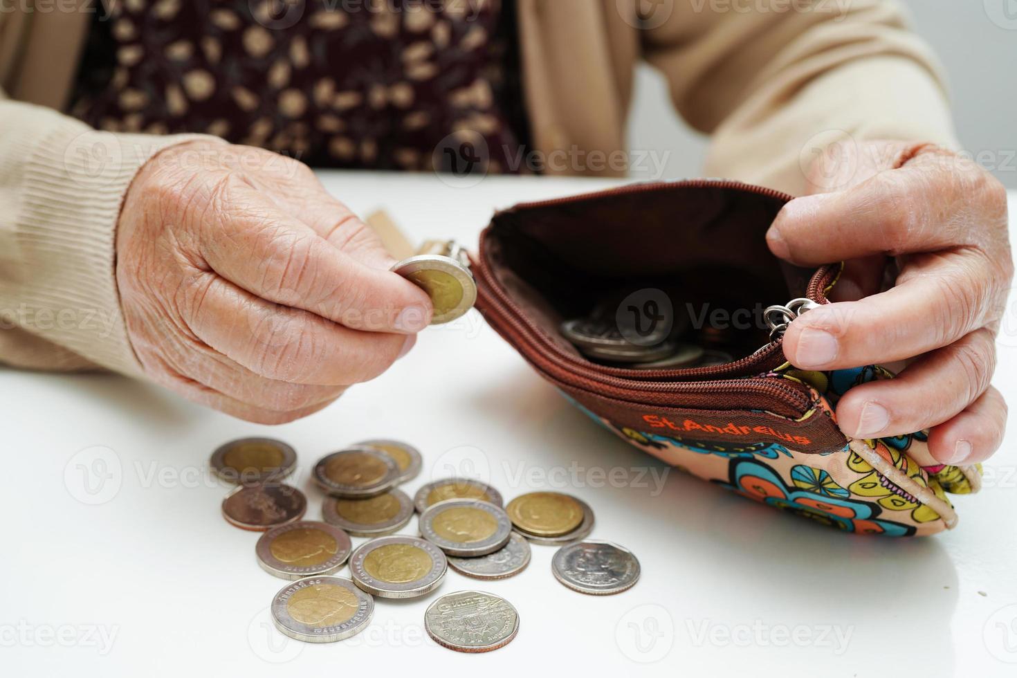 Retired elderly woman counting coins money and worry about monthly expenses and treatment fee payment. photo