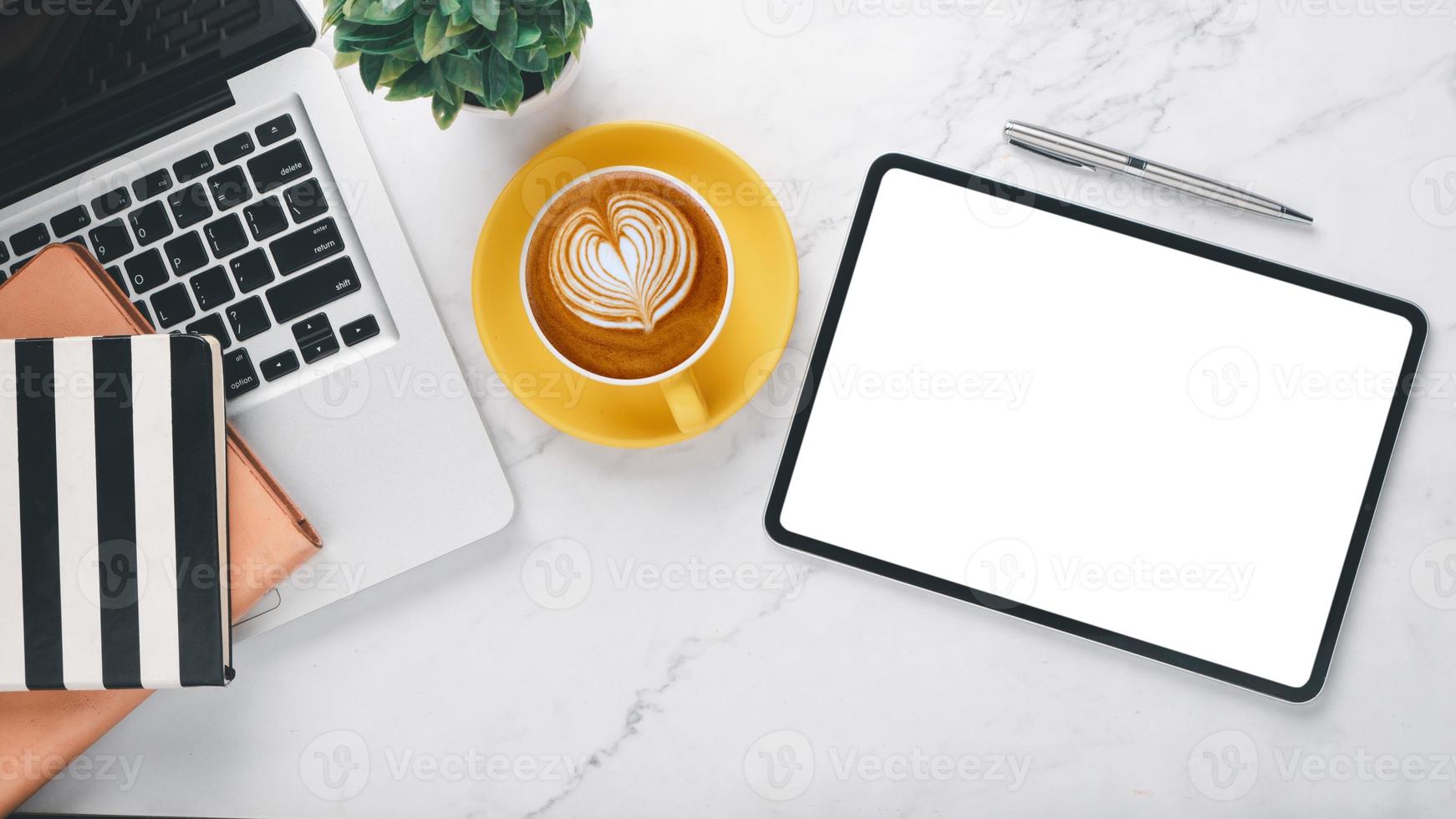 White office desk workplace with blank screen tablet computer, laptop, pen, notebook and cup of coffee, Top view flat lay with copy space. photo