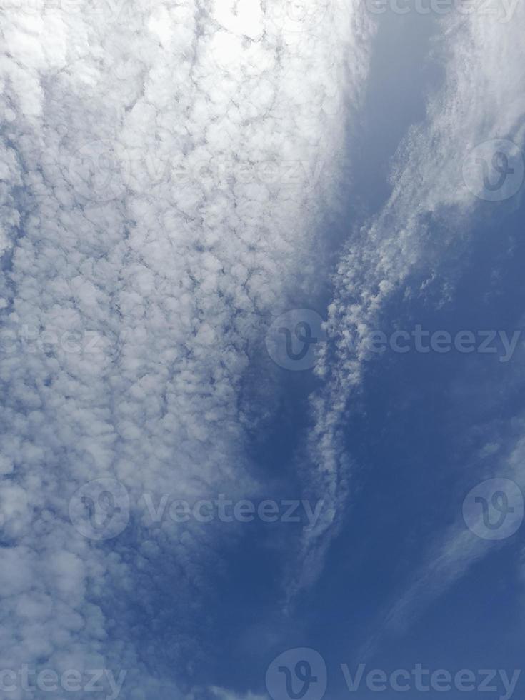 Beautiful white clouds on deep blue sky background. Large bright soft fluffy clouds are cover the entire blue sky. photo