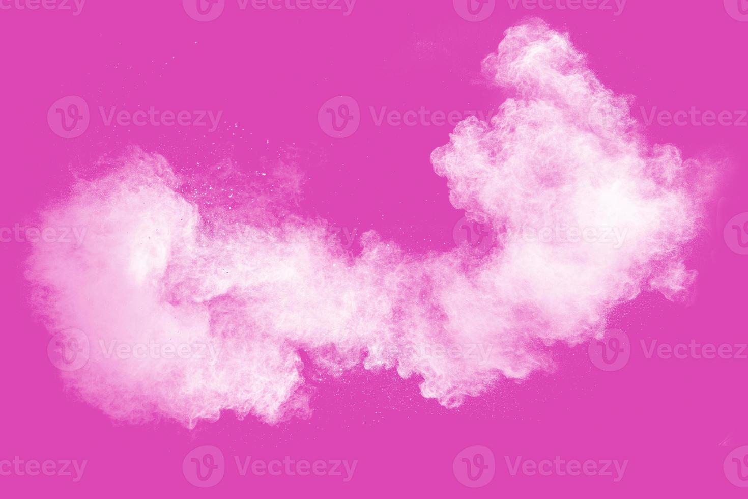 White powder explosion on pink background.White dust particle splashing. photo