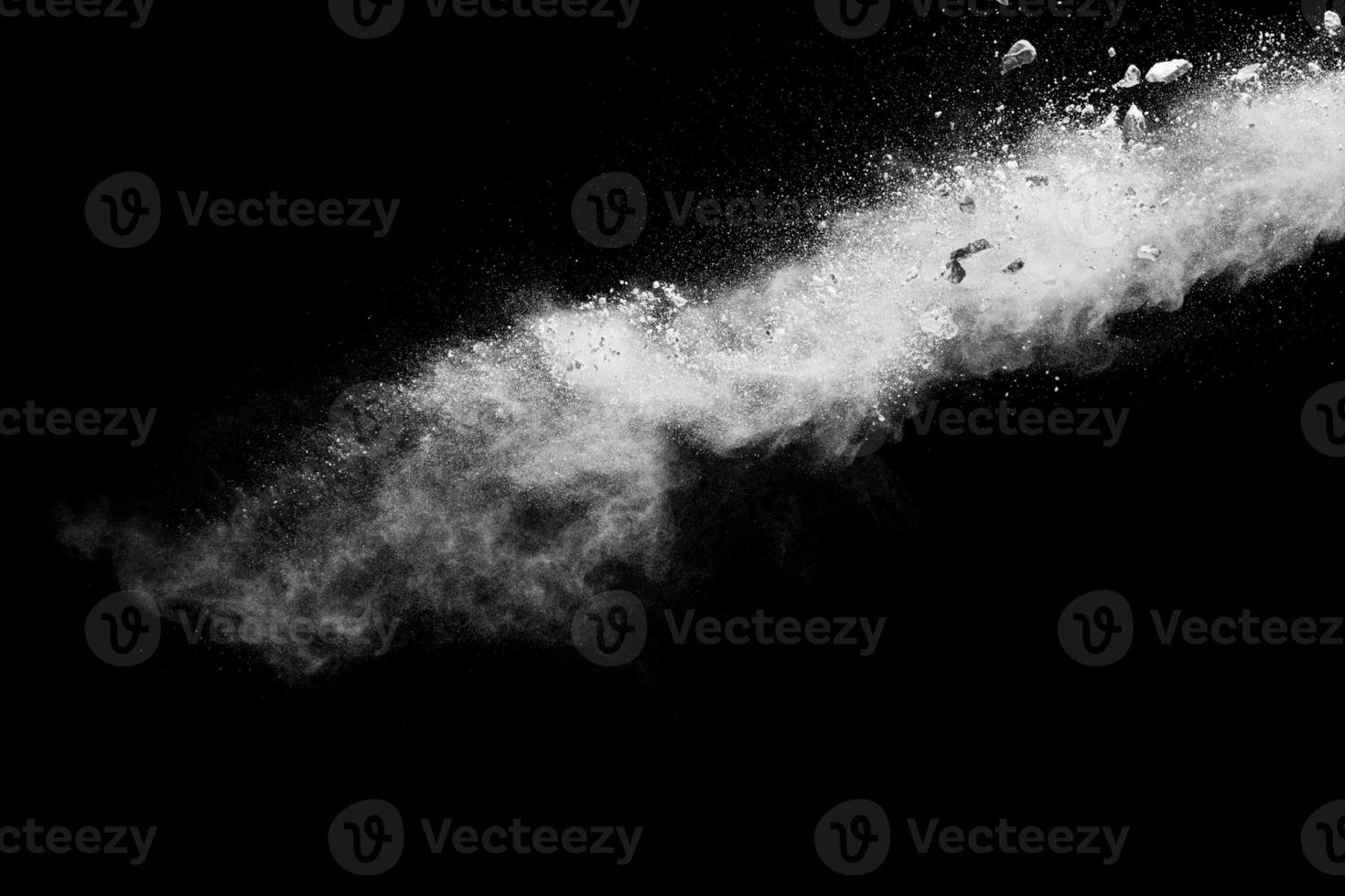 Split debris of stone exploding with white dust against black background. photo