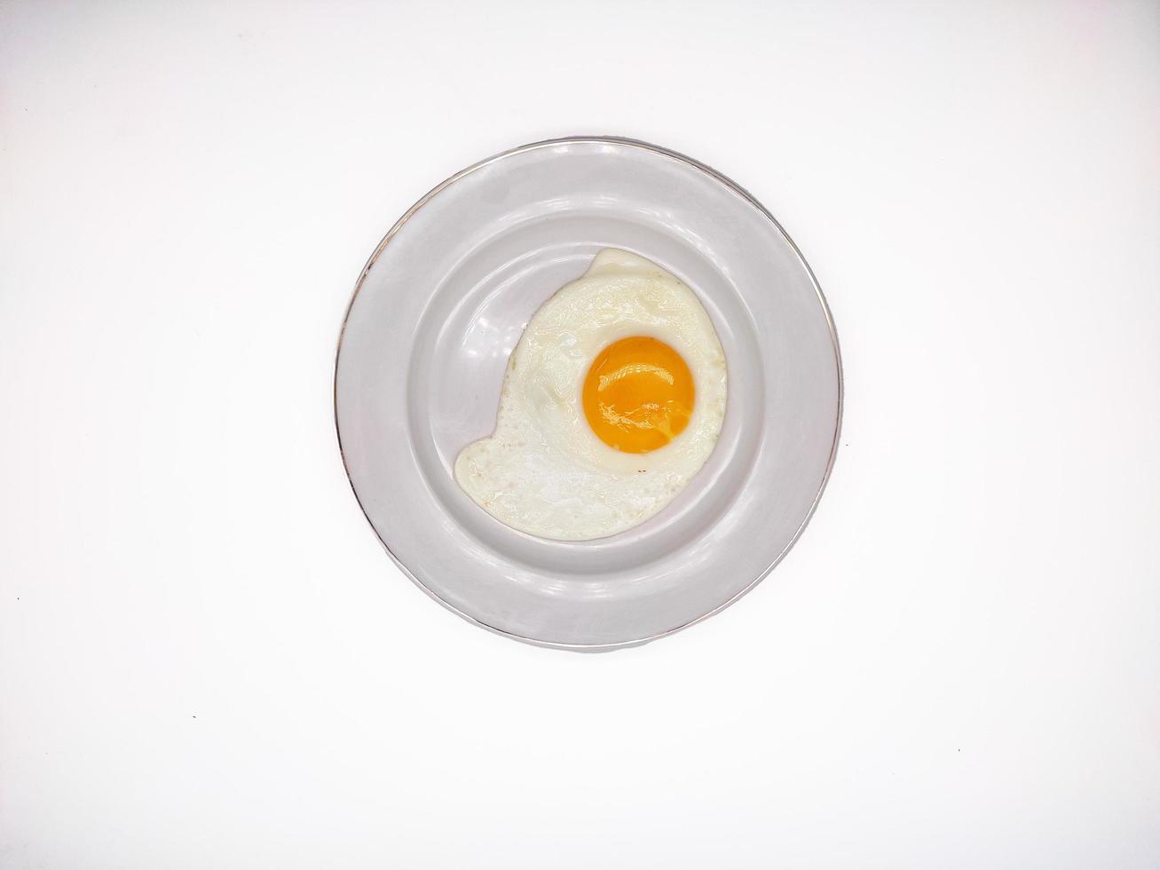 Telor Ceplok or telor mata sapi or sunny side up egg served in white plate isolated in white background photo
