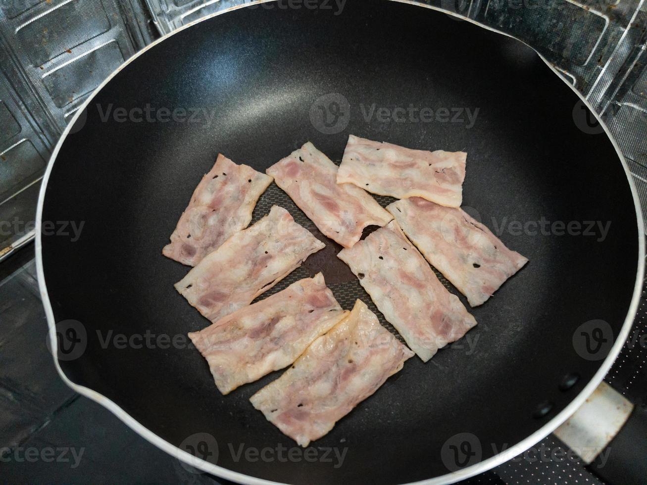 The smoked bacon grilled on the non-stick pan. photo