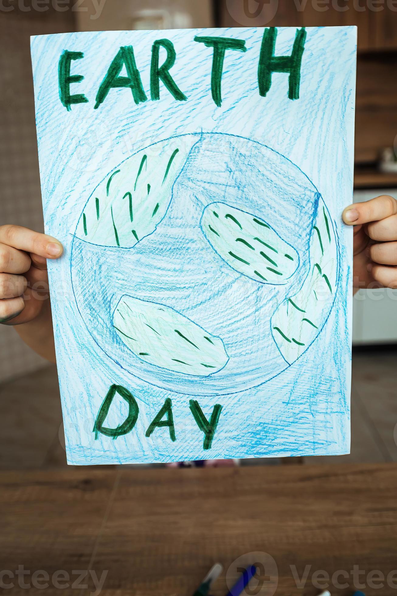 The child holds a drawing of the Earth with a map of the world