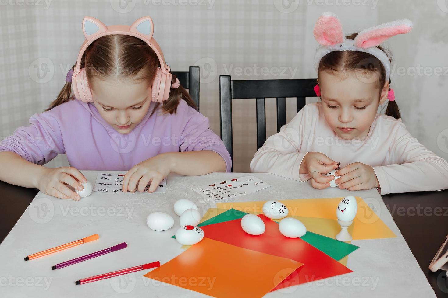 los niños decoran muñecos de huevos blancos, pegan pegatinas con diferentes emociones, estudian emociones foto