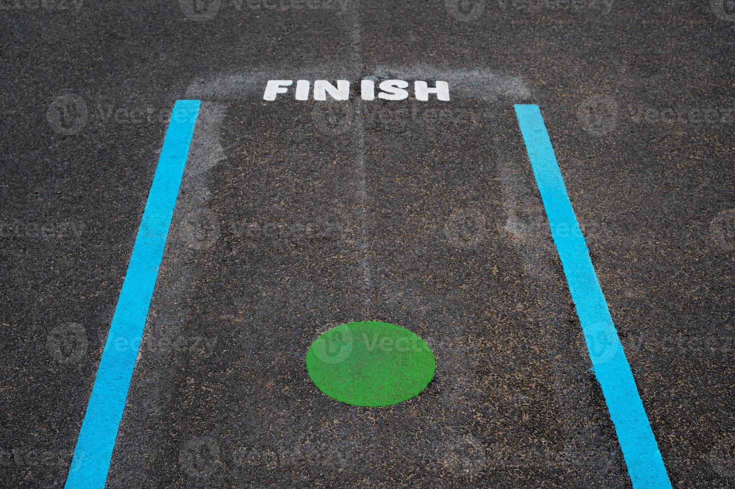 Finish line and Green spot on tarmac floor in School playground,Blue line and Green Circle with Finish word  on pavement at public Park,Outdoor activity for Kids,Learn and Play for Kindergarten photo