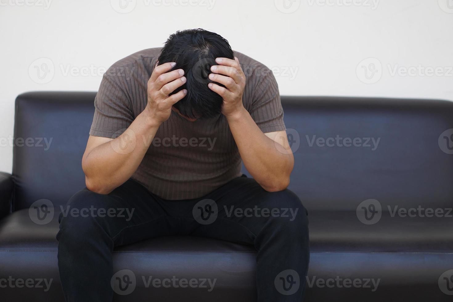 Asian man feels sad, stressed, depressed, hands covered his head. Concept, drepression, failure, disappointment, broken heart. guilty, have life problems. photo