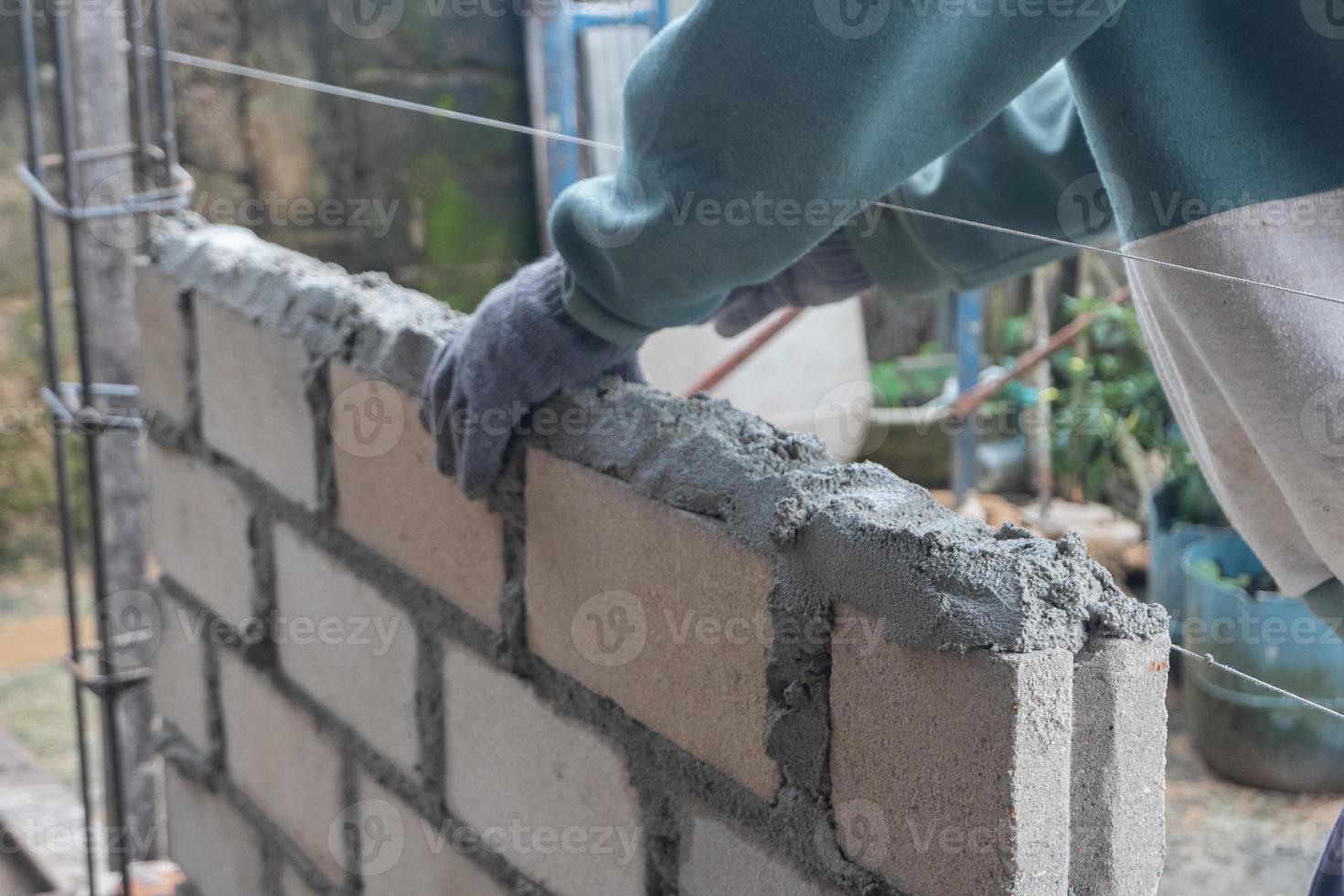 selectivo atención en ladrillos siendo instalado por constructores, concepto foto de el proceso de edificio un casa, depósito. suave atención