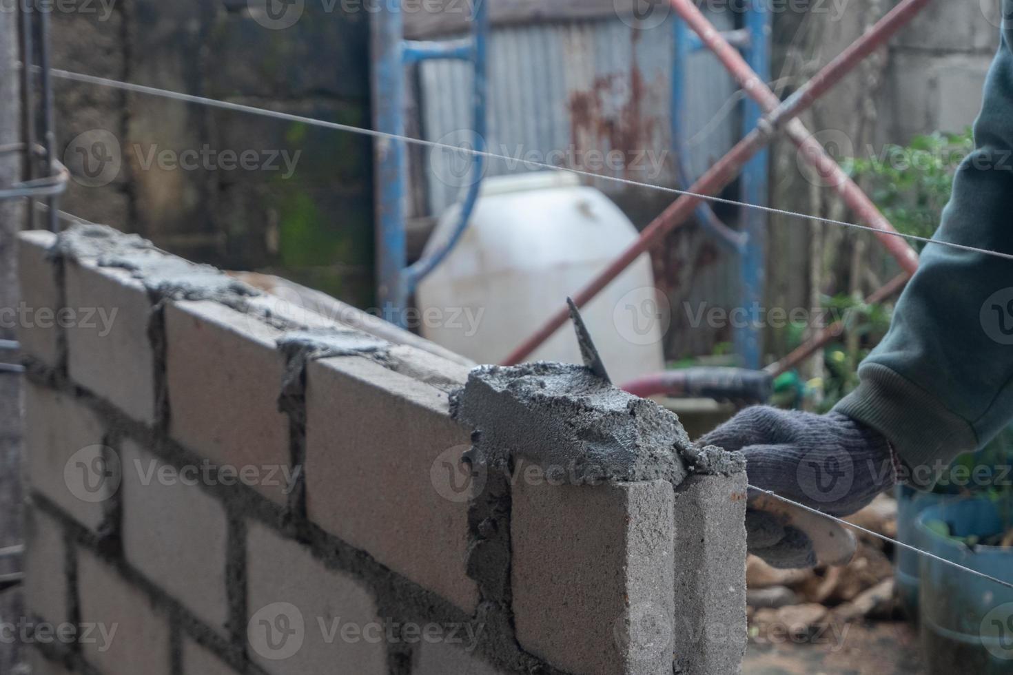 selective focus on bricks being installed by builders, concept photo of the process of building a house, warehouse. soft focus