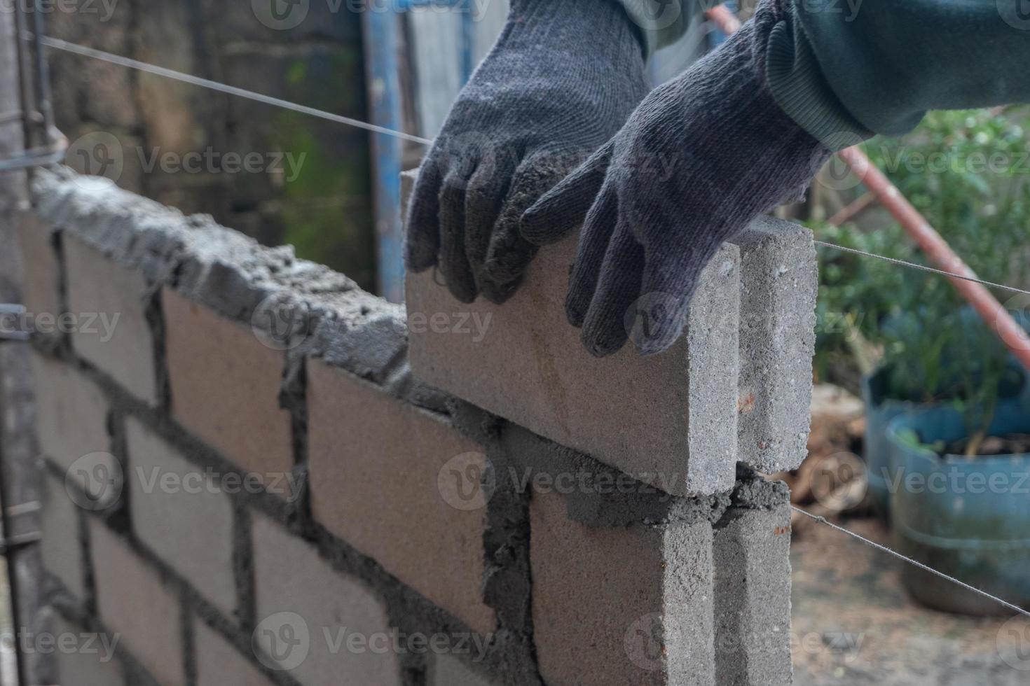 selectivo atención en ladrillos siendo instalado por constructores, concepto foto de el proceso de edificio un casa, depósito. suave atención