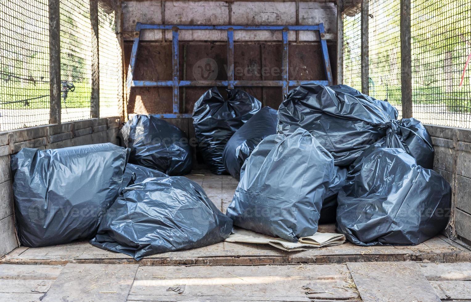 Black garbage bags on back of garbage truck photo