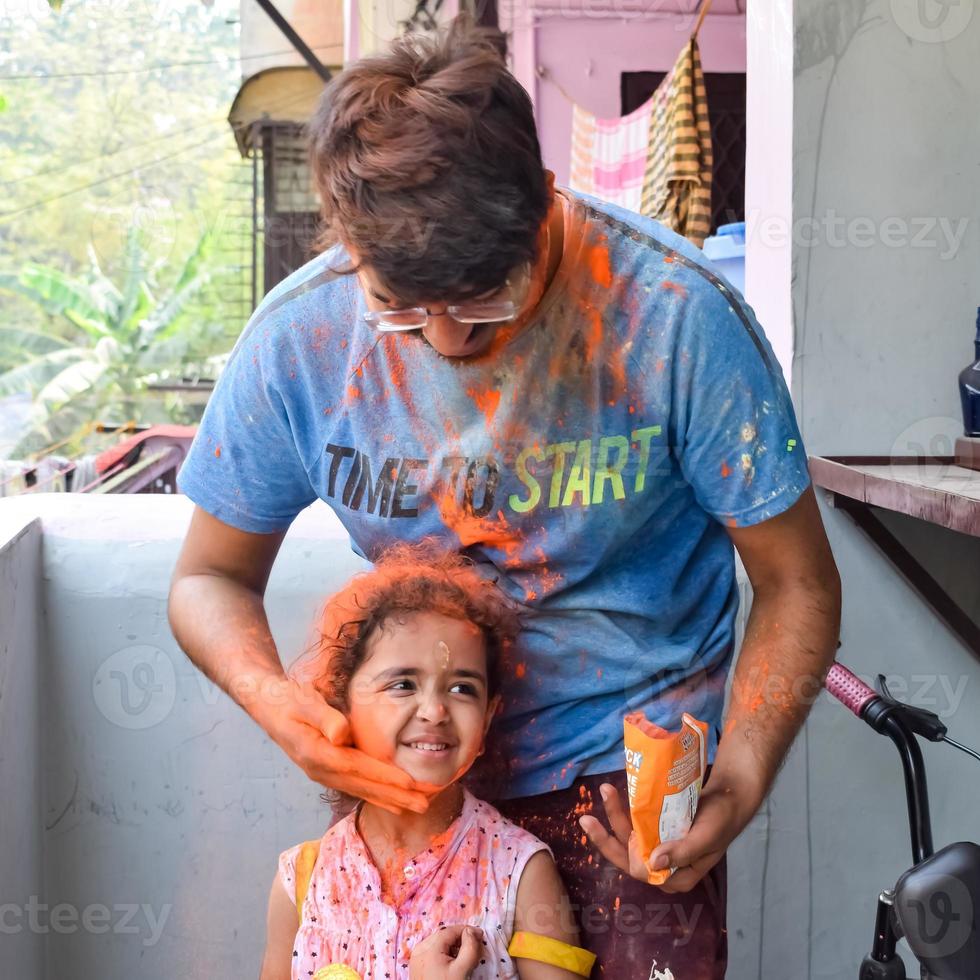 indio familia personas jugando colores en holi festival, participación diferente colores, holi festival celebraciones en Delhi, India foto