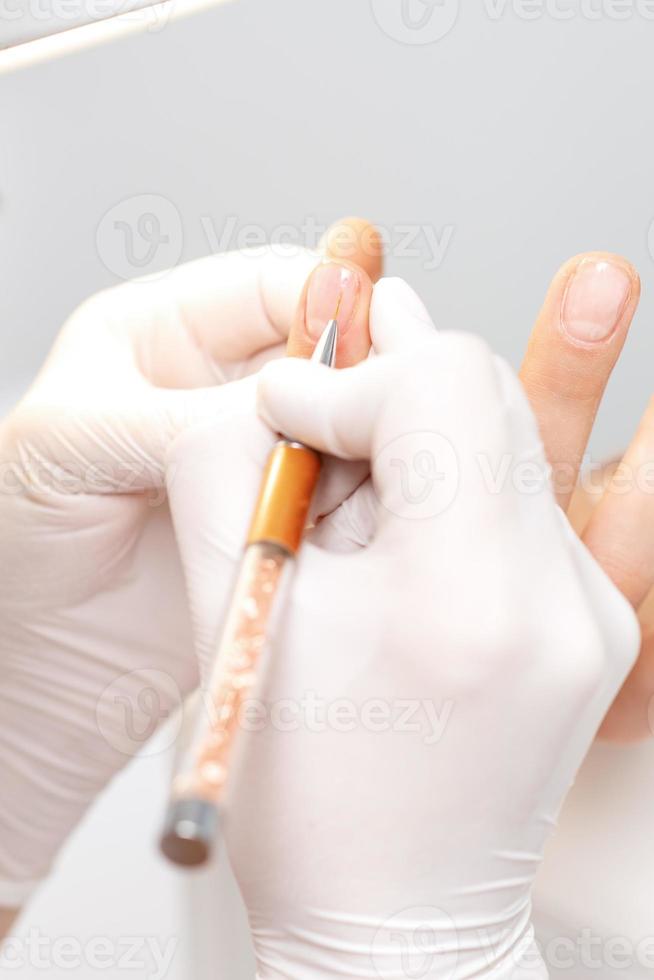 Manicurist drawing decorations by gel pencil photo