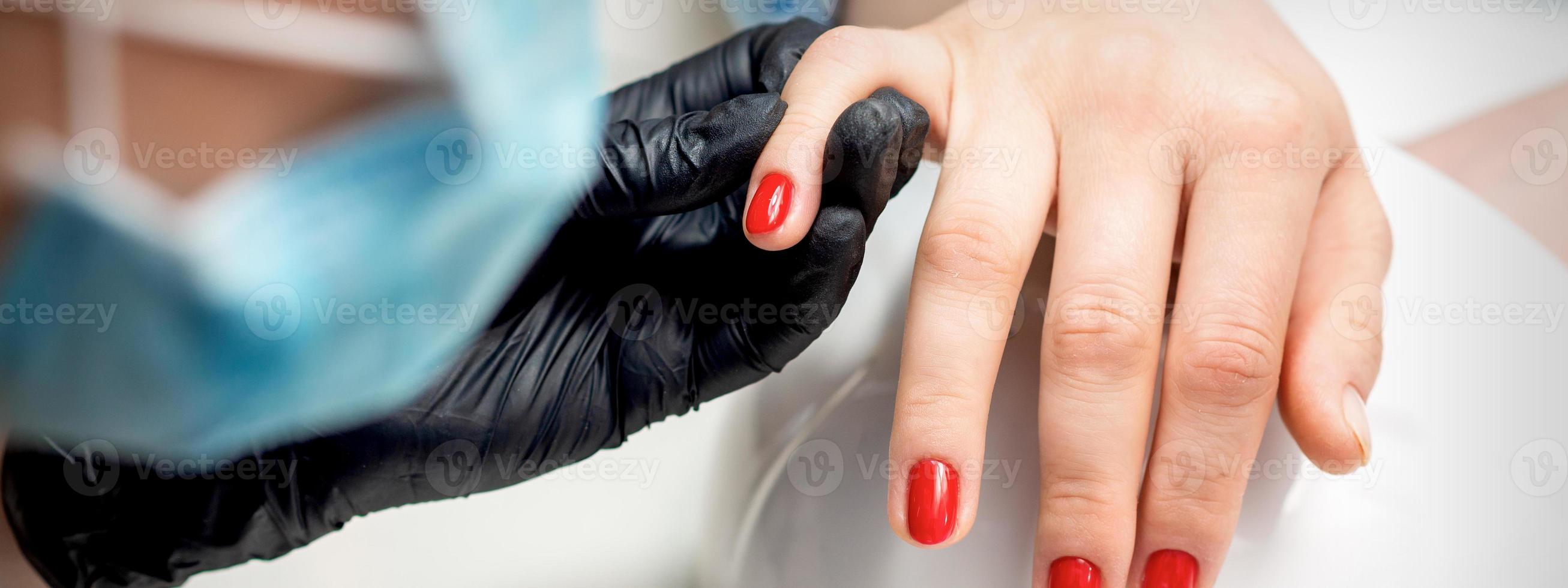 joven mujer recibe rojo uña polaco foto