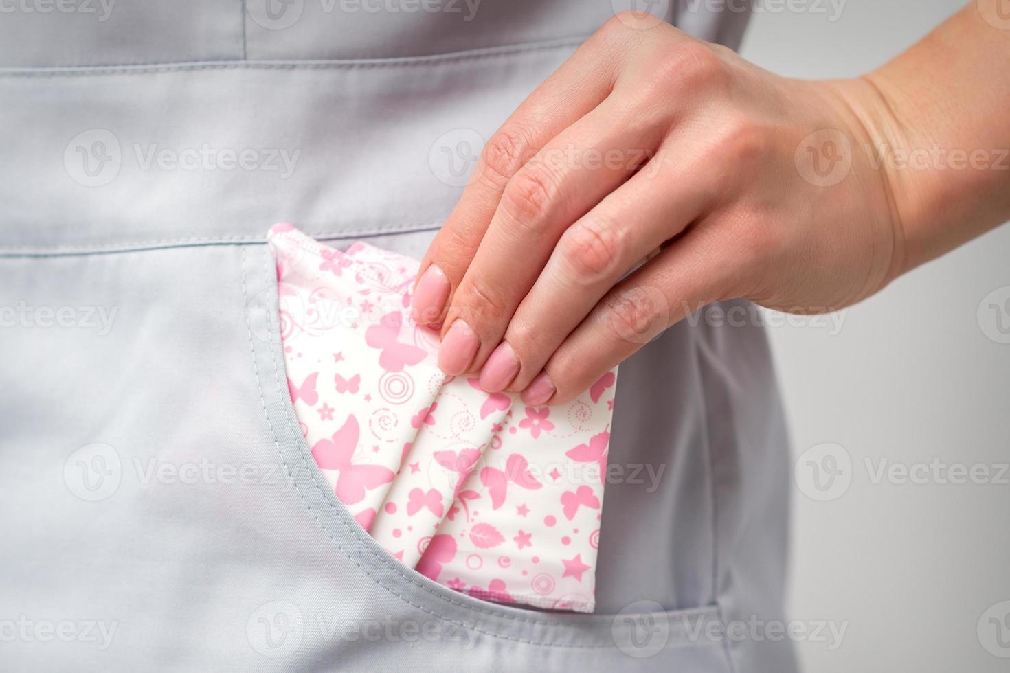 Female hand puts menstrual pads into pocket photo