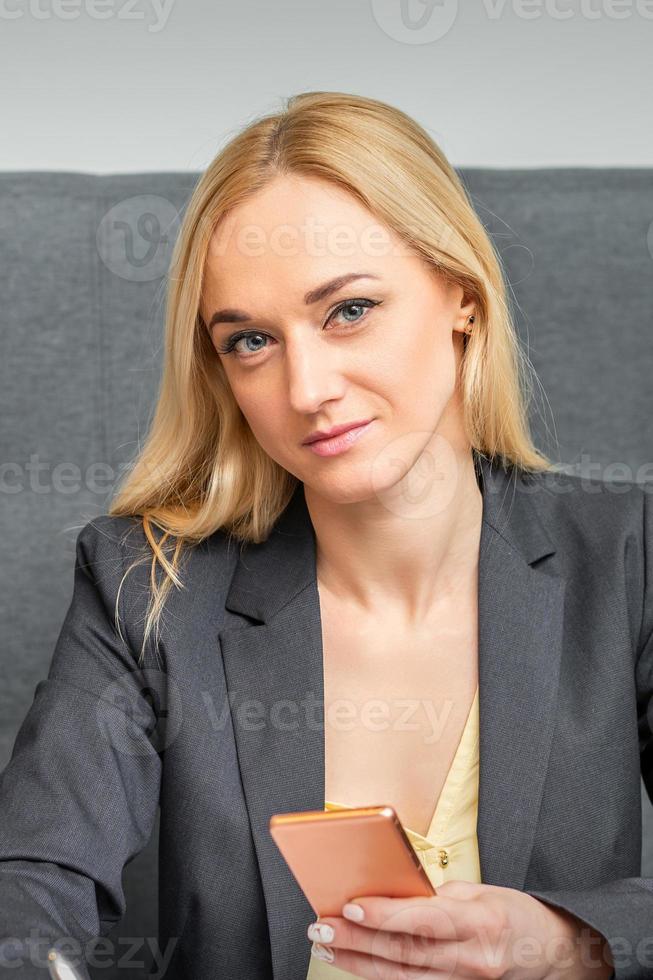 Businesswoman with smartphone working in office photo