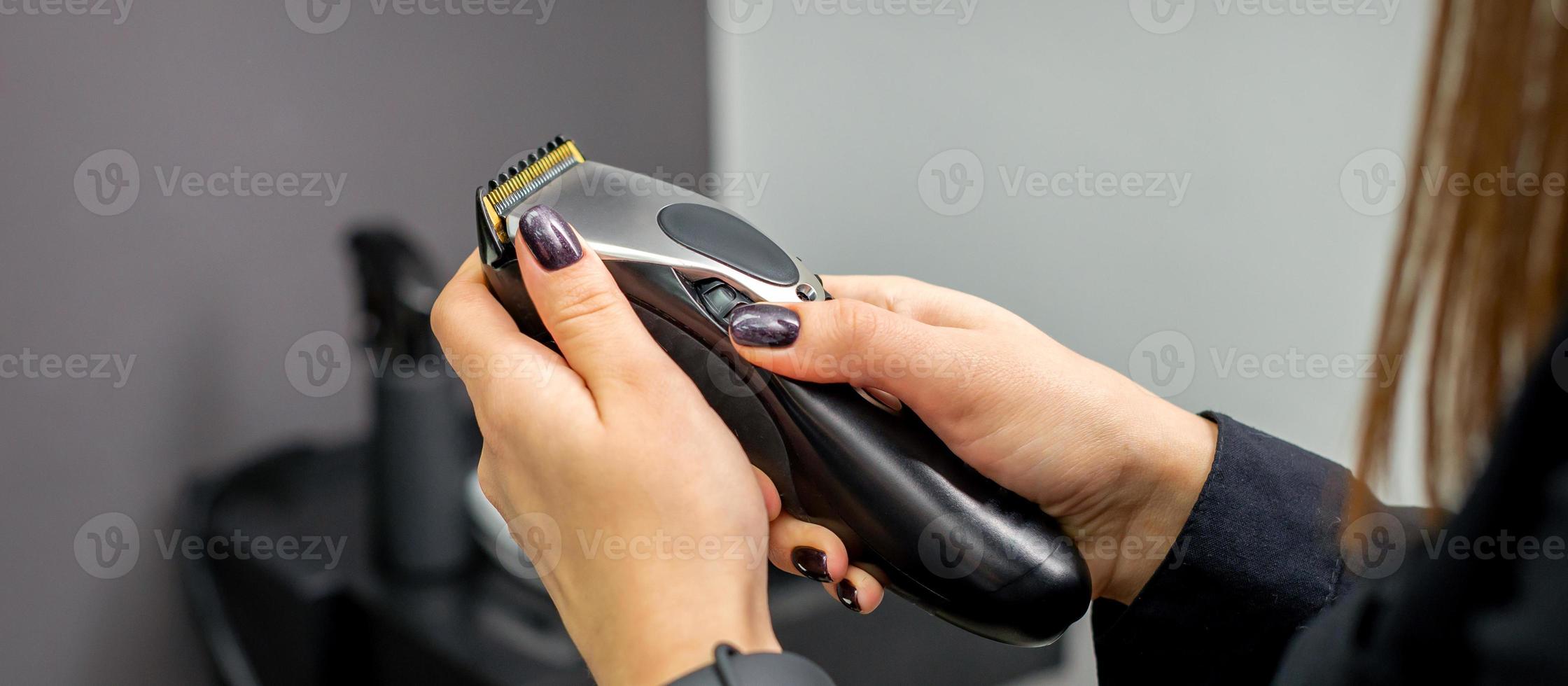 Hair clipper in hands of female photo