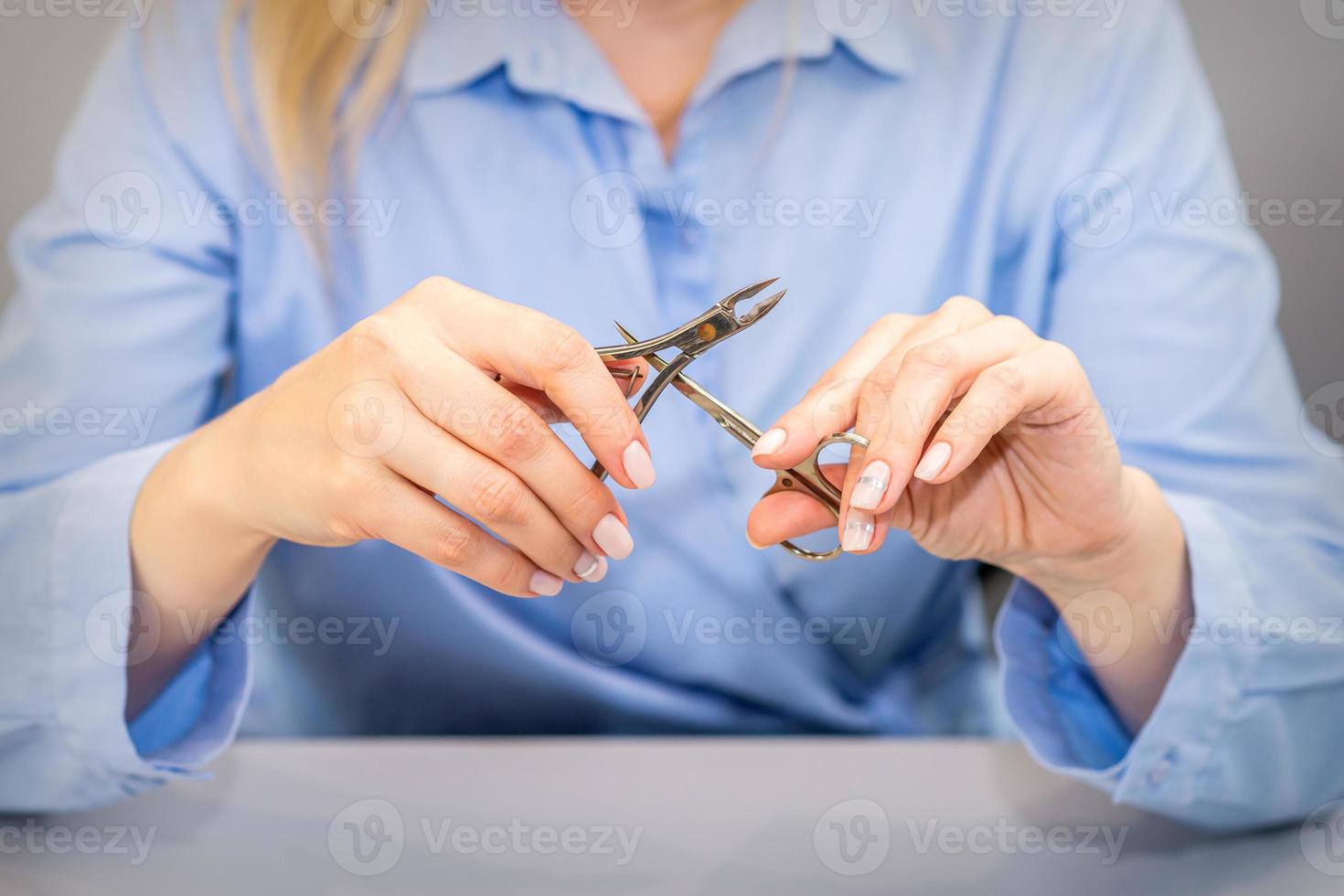 Female manicurist holds manicure tools photo