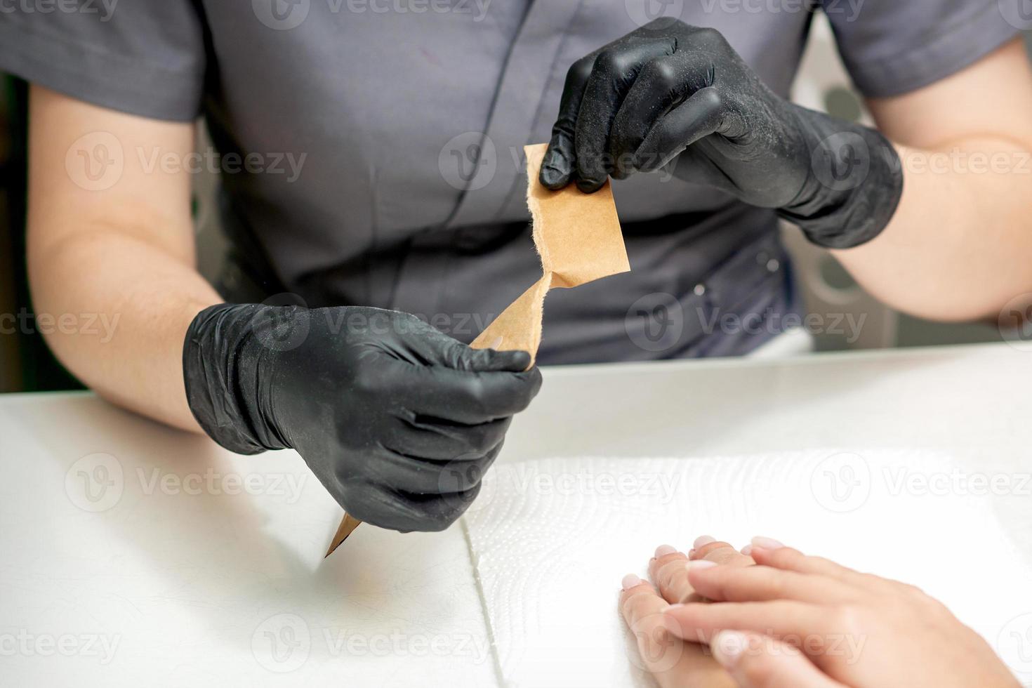 Manicure master opening craft envelope with manicure tools photo