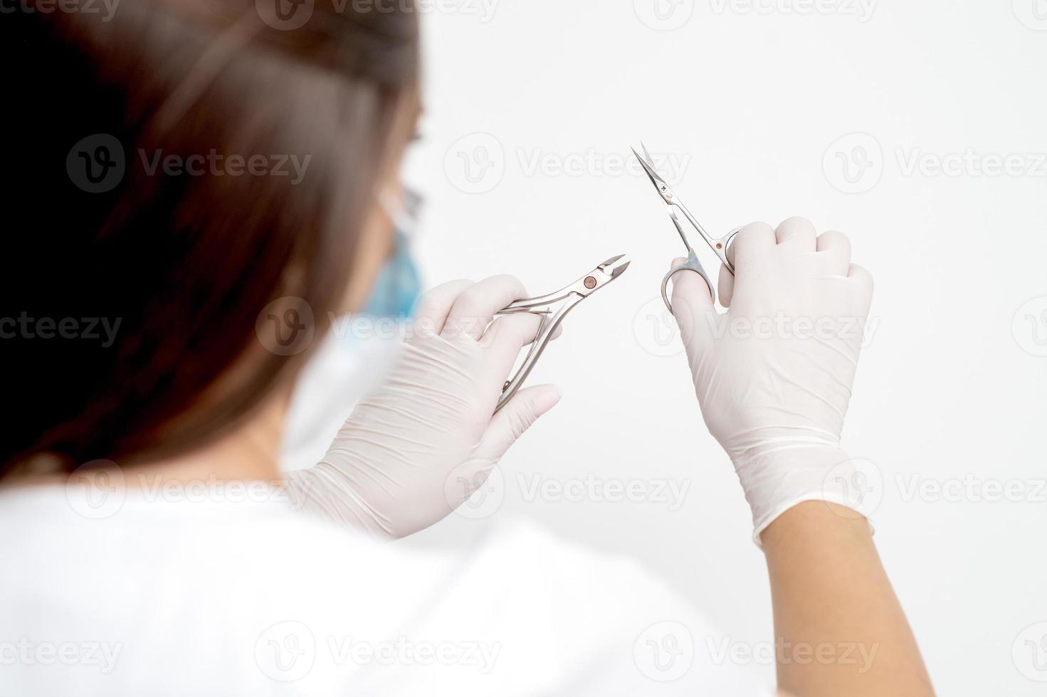 Manicure tools in hands of female manicurist photo