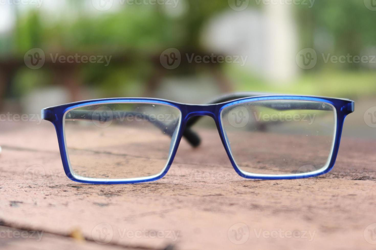 blue color eyeglass and smart phone on table photo