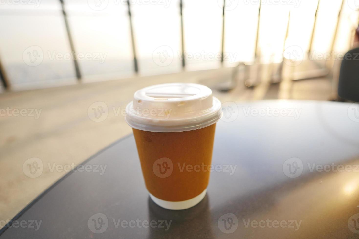 take away paper coffee cup o on cafe table photo