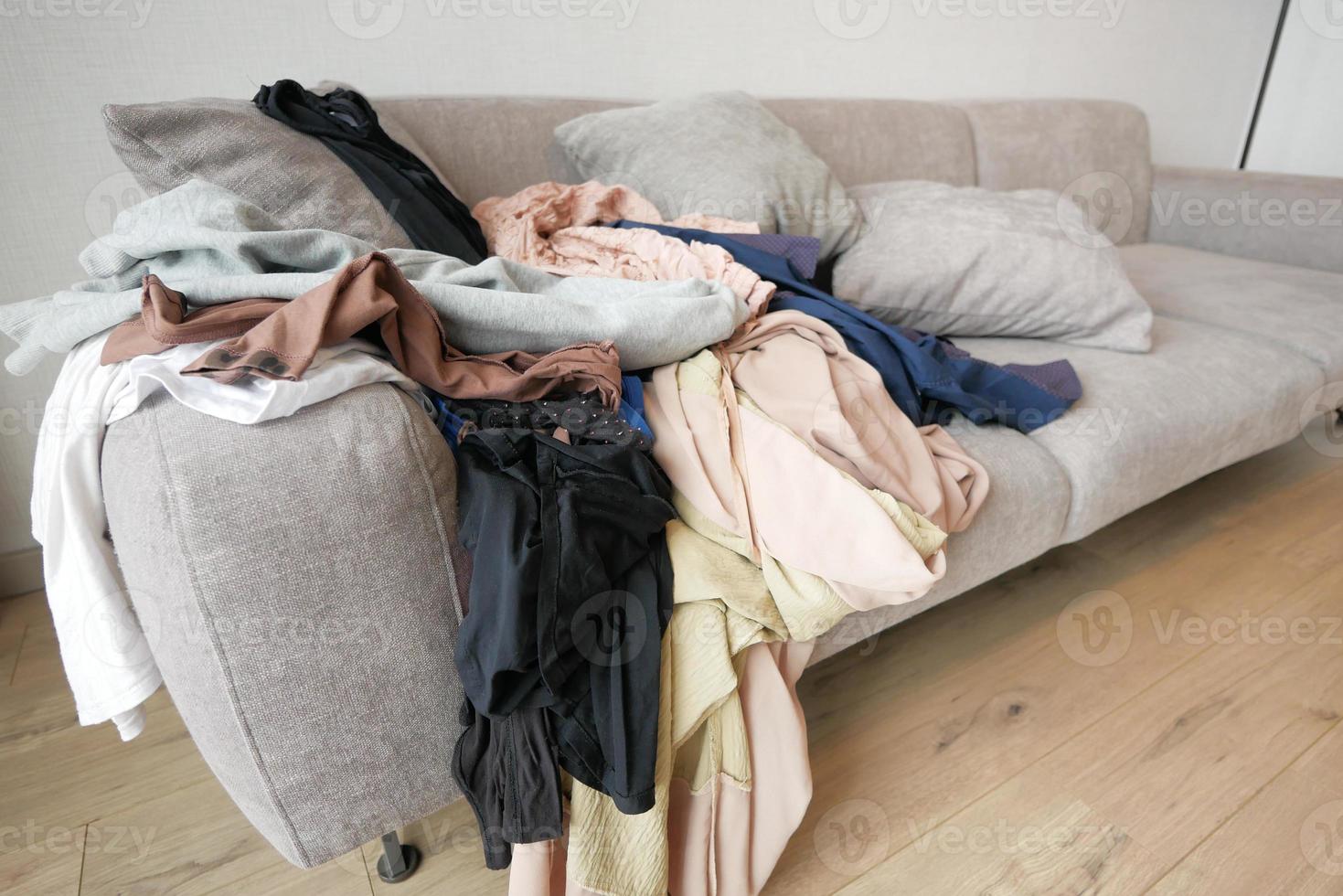 Messy clothes on sofa at home photo