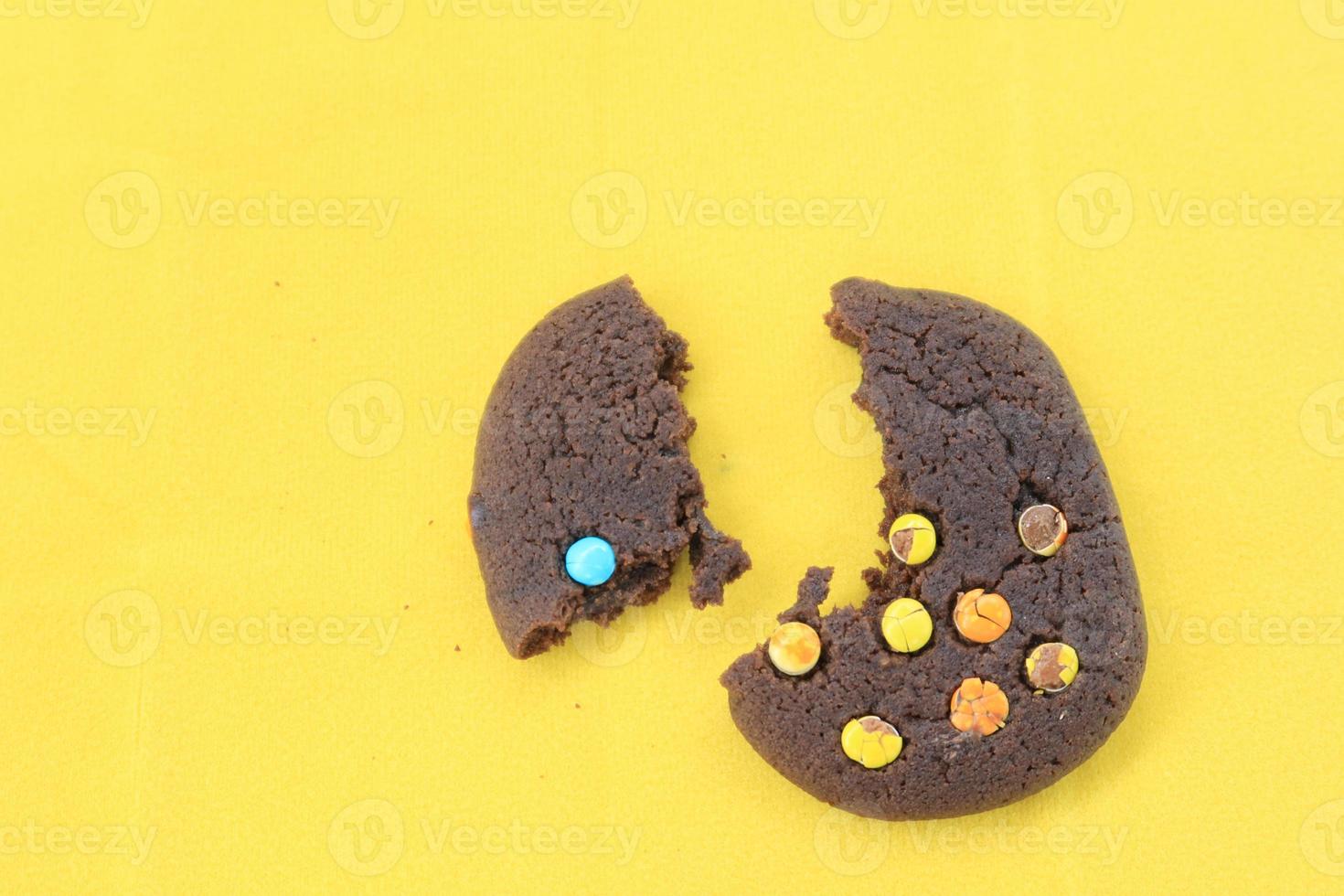 hand eaten chocolate chip cookies on yellow background close up photo