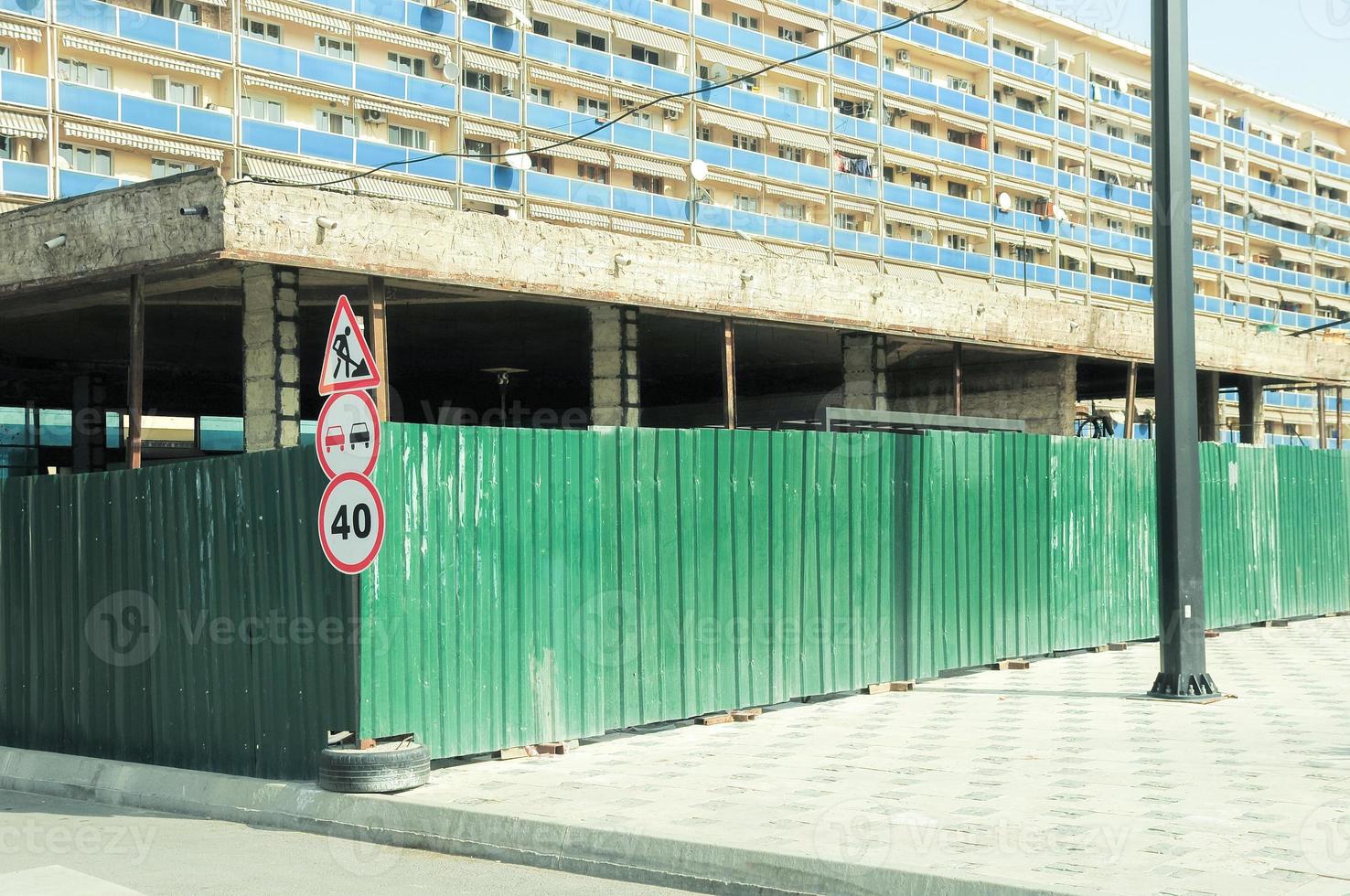 Subway station under construction. Construction site surrounded with a green zinc fence. photo