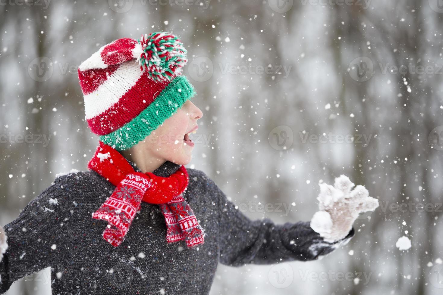 Funny little boy in winter clothes walks during a snowfall. Winter ...