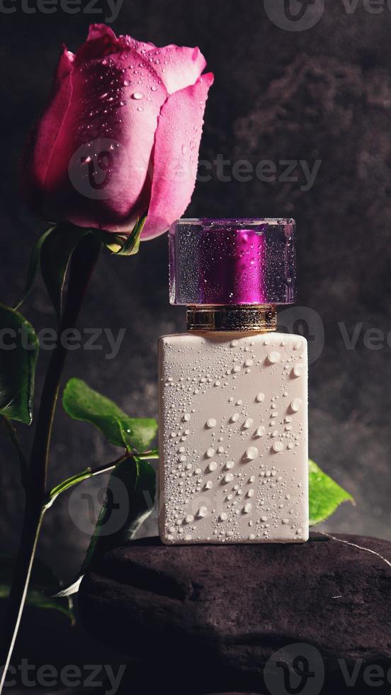 White perfume bottle with purple top and rose with water drops. mockup photo