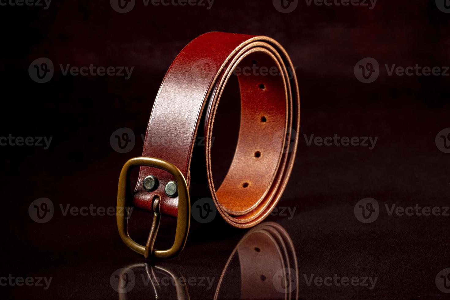 Brown leather belt on a dark background. photo