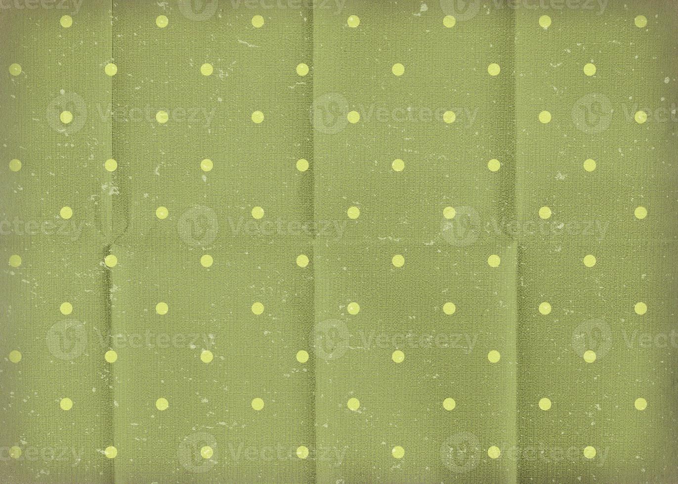 Vintage green crumpled paper with white polka dots. Old worn paper wallpaper with cracks. photo