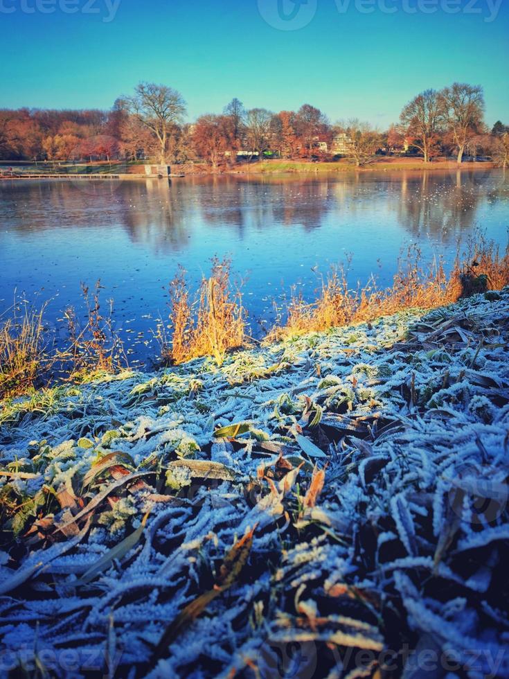 Frosty morning at the lake. Beautiful winter landscape with frozen lake. photo