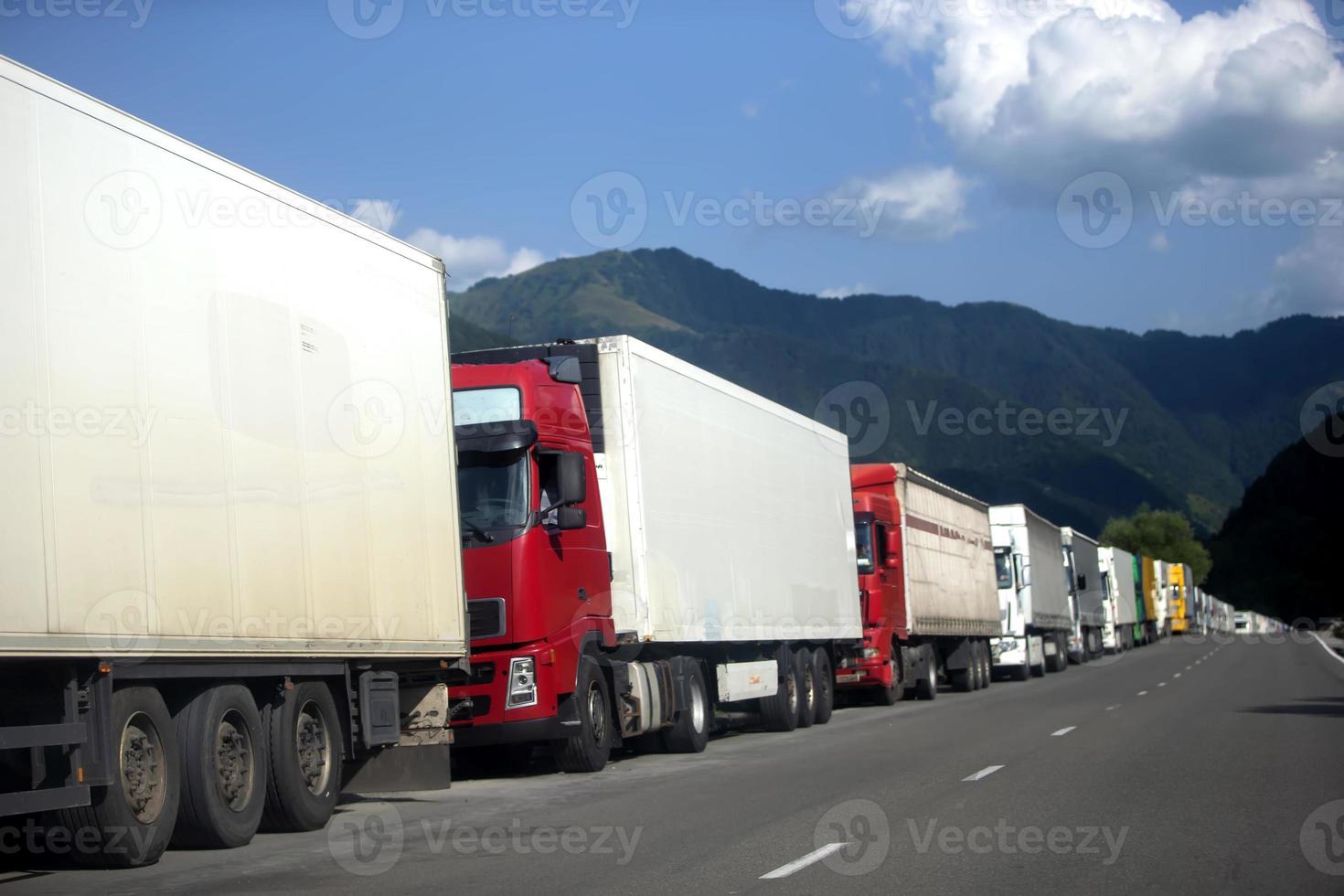 Row of trucks on the road. Trucks are waiting in line at customs. photo