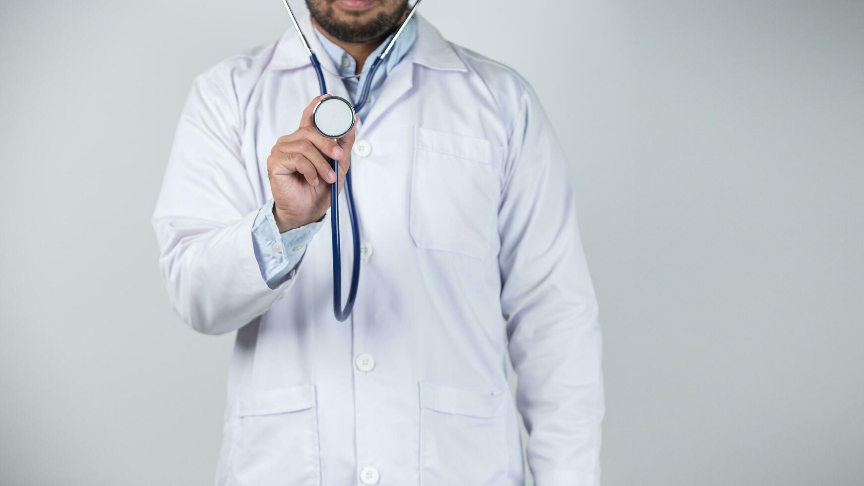 male doctor is holding stethoscope into the camera photo