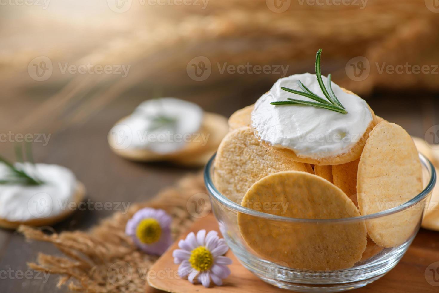 delicioso galletas con crema queso y Romero en parte superior en taza. foto