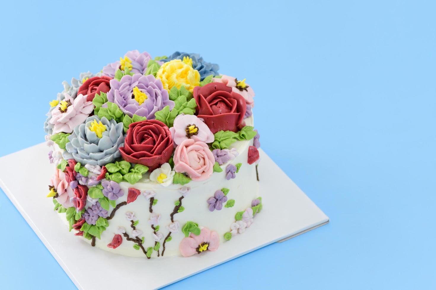 Homemade cake decorated with beautiful flowers on blue background, photo