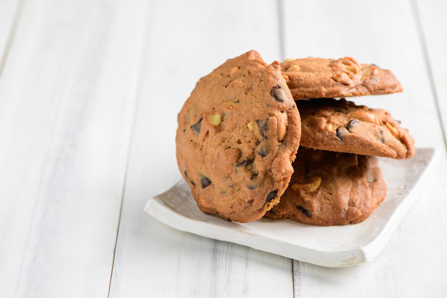 Homemade pastry cookies on white dish on white wood background, photo