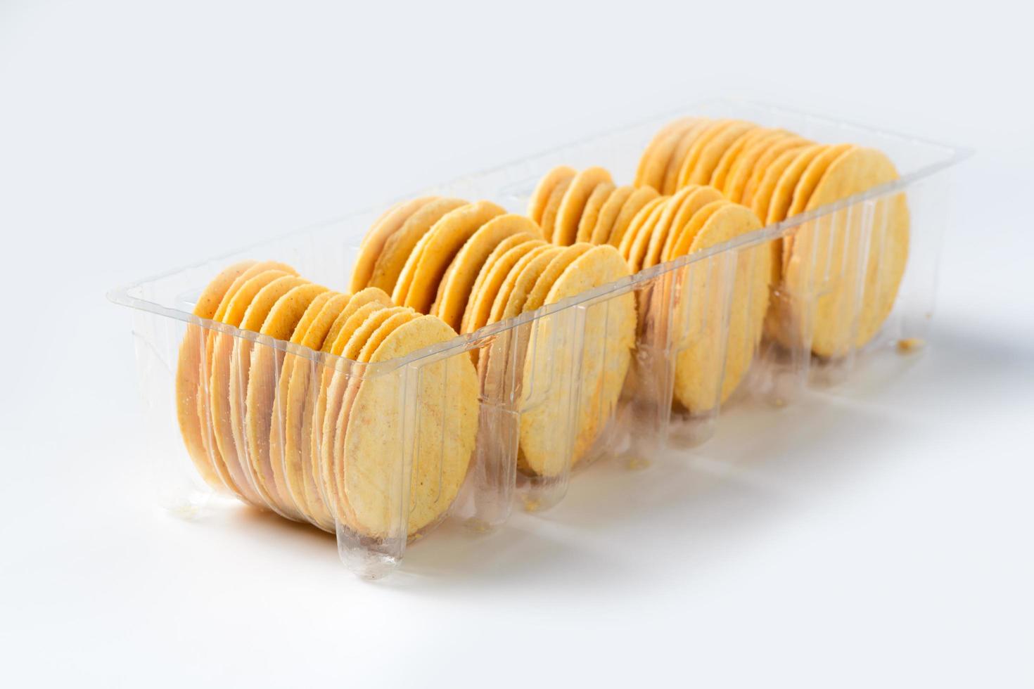 Round Crackers biscuits in plastic box isolated on white background, photo
