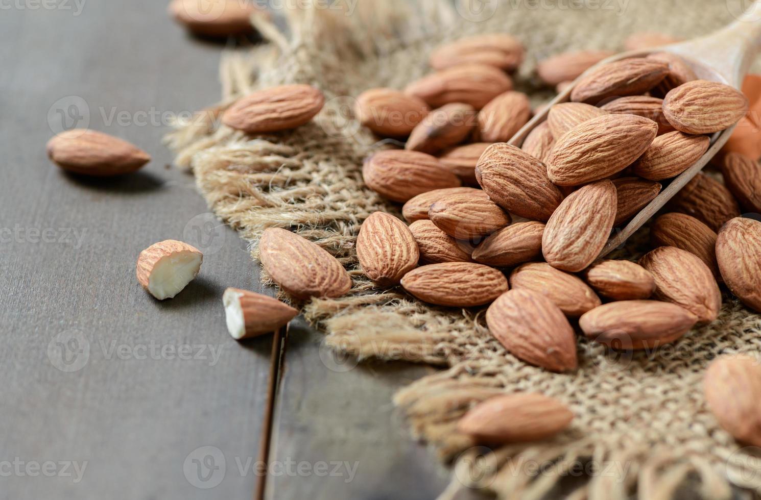 Almendras nuez en madera cuchara en madera antecedentes. foto