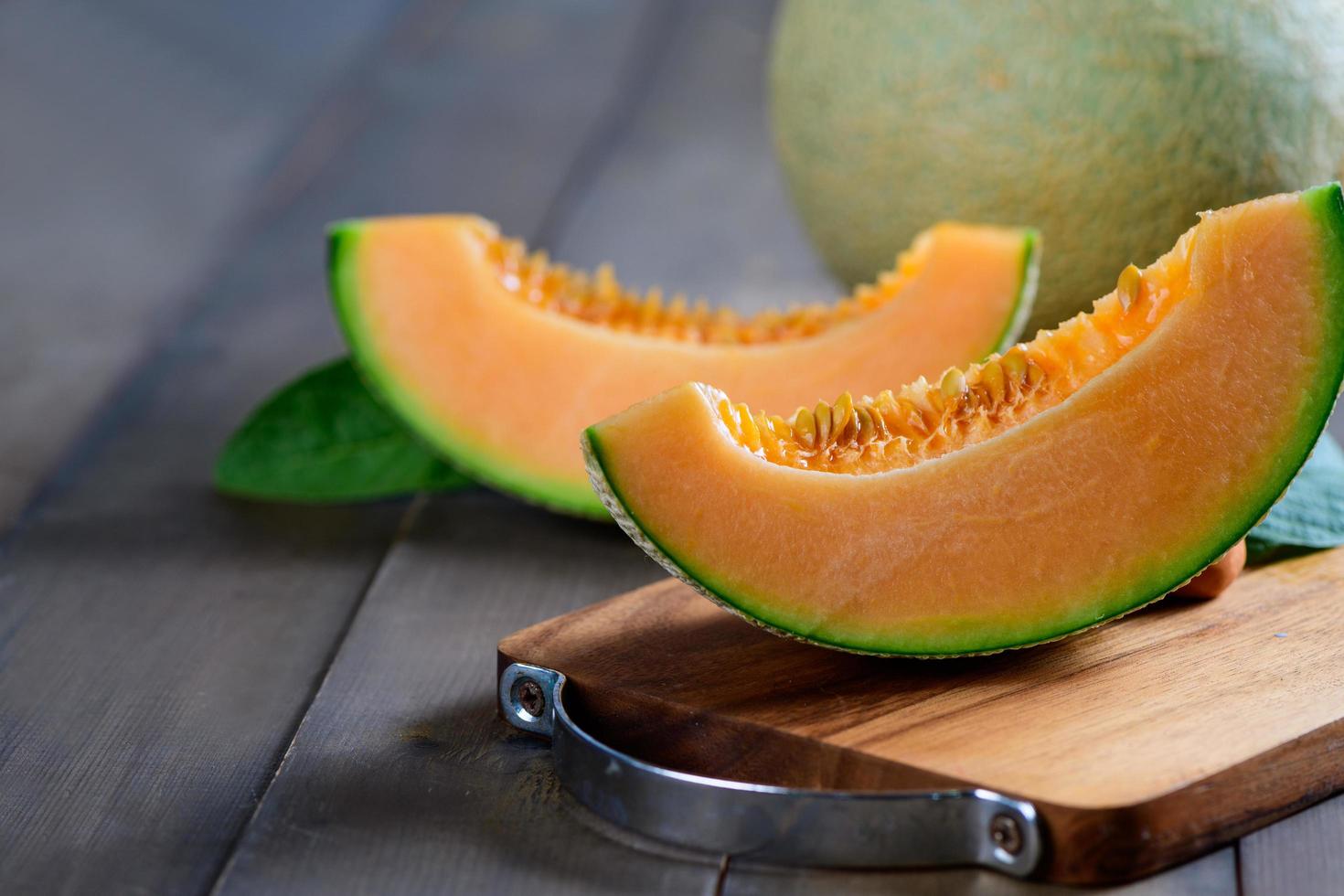 slice of japanese melons, orange melon or cantaloupe melon on wood background, photo