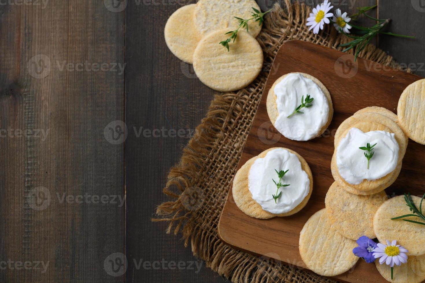Delicious crackers with cream cheese and rosemary on top. Cookies with cream cheese photo