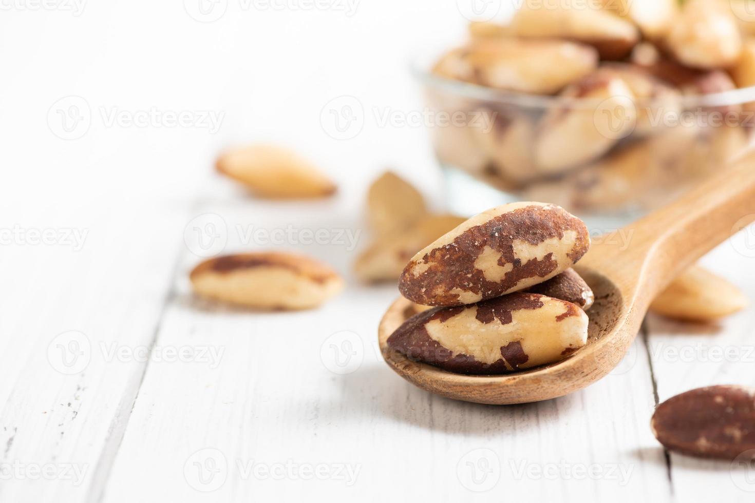 Brasil nueces en madera cuchara y espacio para texto en blanco de madera fondo, foto